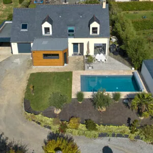 Piscine classique 11x5m avec liner gris clair, margelles en travertin et volet immergé IN'DECK. Sobriété, confort et technologie réunis – Bonheur Piscines