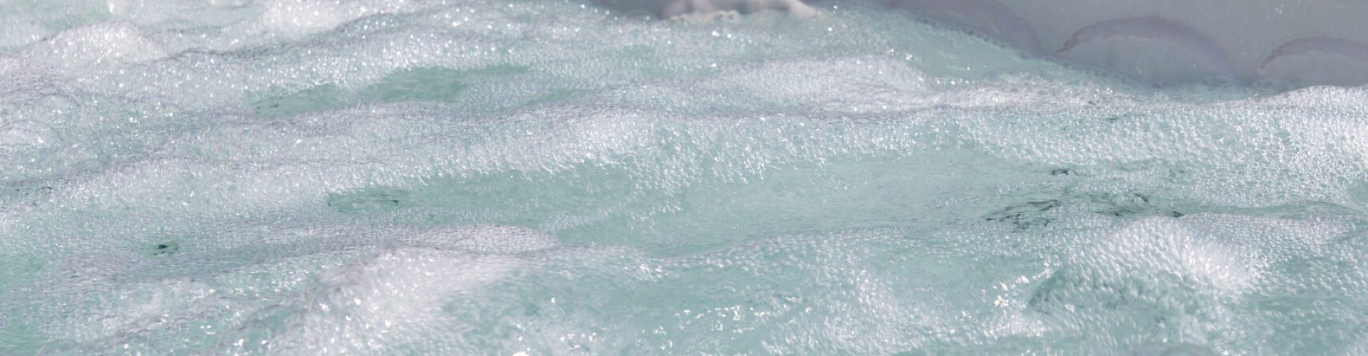 Spa accessible depuis la plage en pierre naturelle, le tout dans un cadre paysager. – Hénocque Piscines et Spas