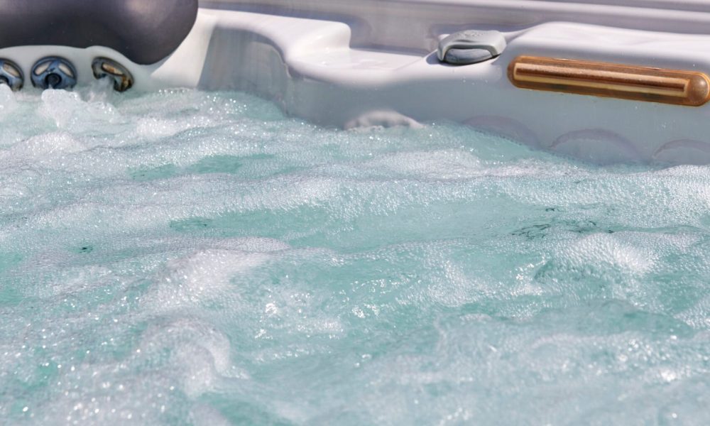 Spa accessible depuis la plage en pierre naturelle, le tout dans un cadre paysager. – Hénocque Piscines et Spas