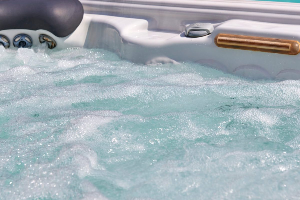 Spa accessible depuis la plage en pierre naturelle, le tout dans un cadre paysager. – Hénocque Piscines et Spas